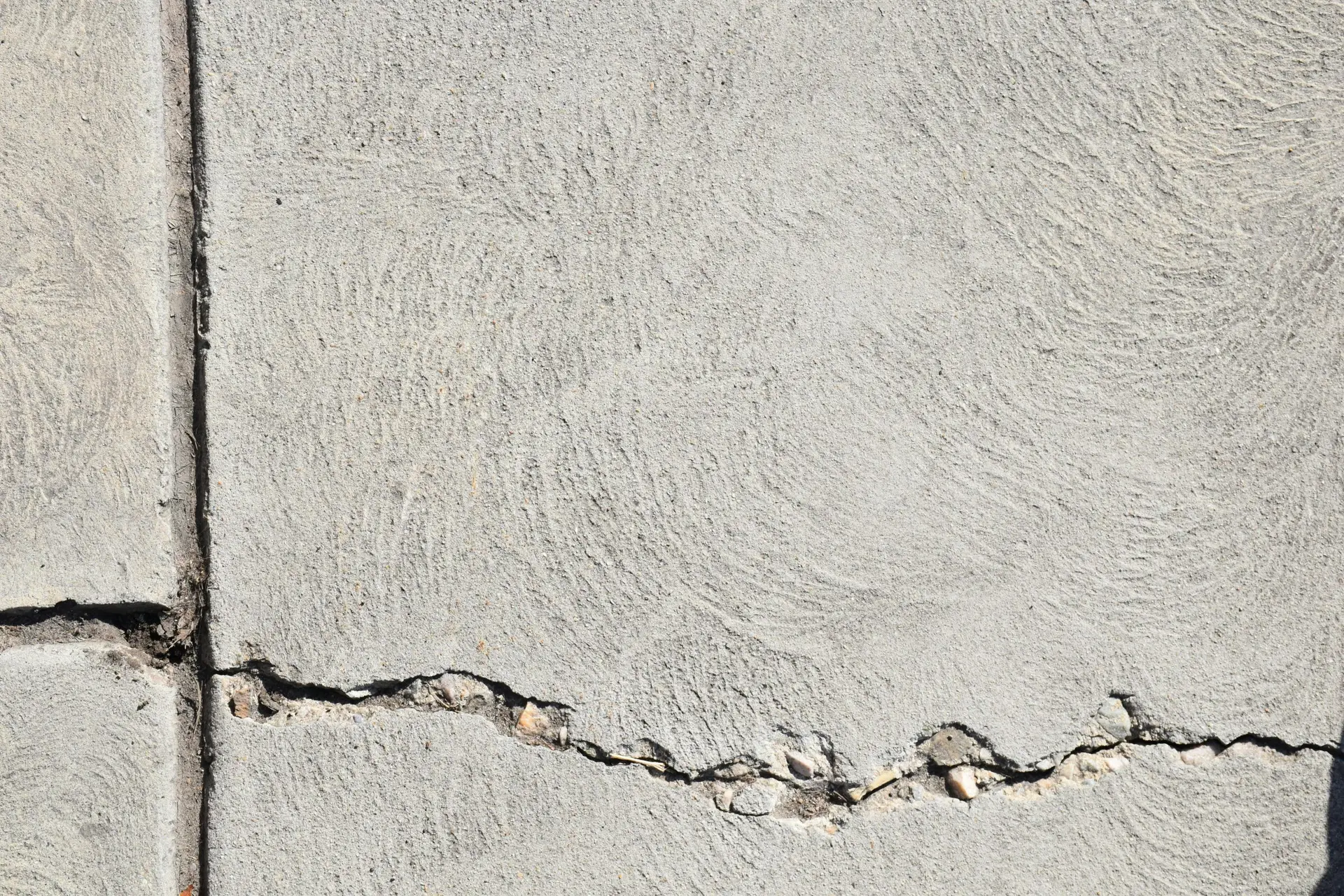 Close-up view of a cracked concrete surface with distinct textures in Logan, Utah.